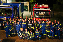 Gruppenfoto des Löschzugs der Freiwilligen Feuerwehr Kölkebeck mit Helfern des THW vor Fahrzeugen.
