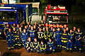 Gruppenfoto des Löschzugs der Freiwilligen Feuerwehr Kölkebeck mit Helfern des THW vor Fahrzeugen.